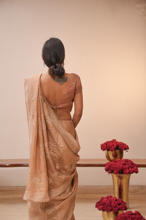 A model showcasing Brown Organza Chikankari Saree by Myra By Anju Narian from Myra By Anju Narian's collection A model showcasing Brown Organza Chikankari Saree by Myra By Anju Narian from Myra By Anju Narian's collection