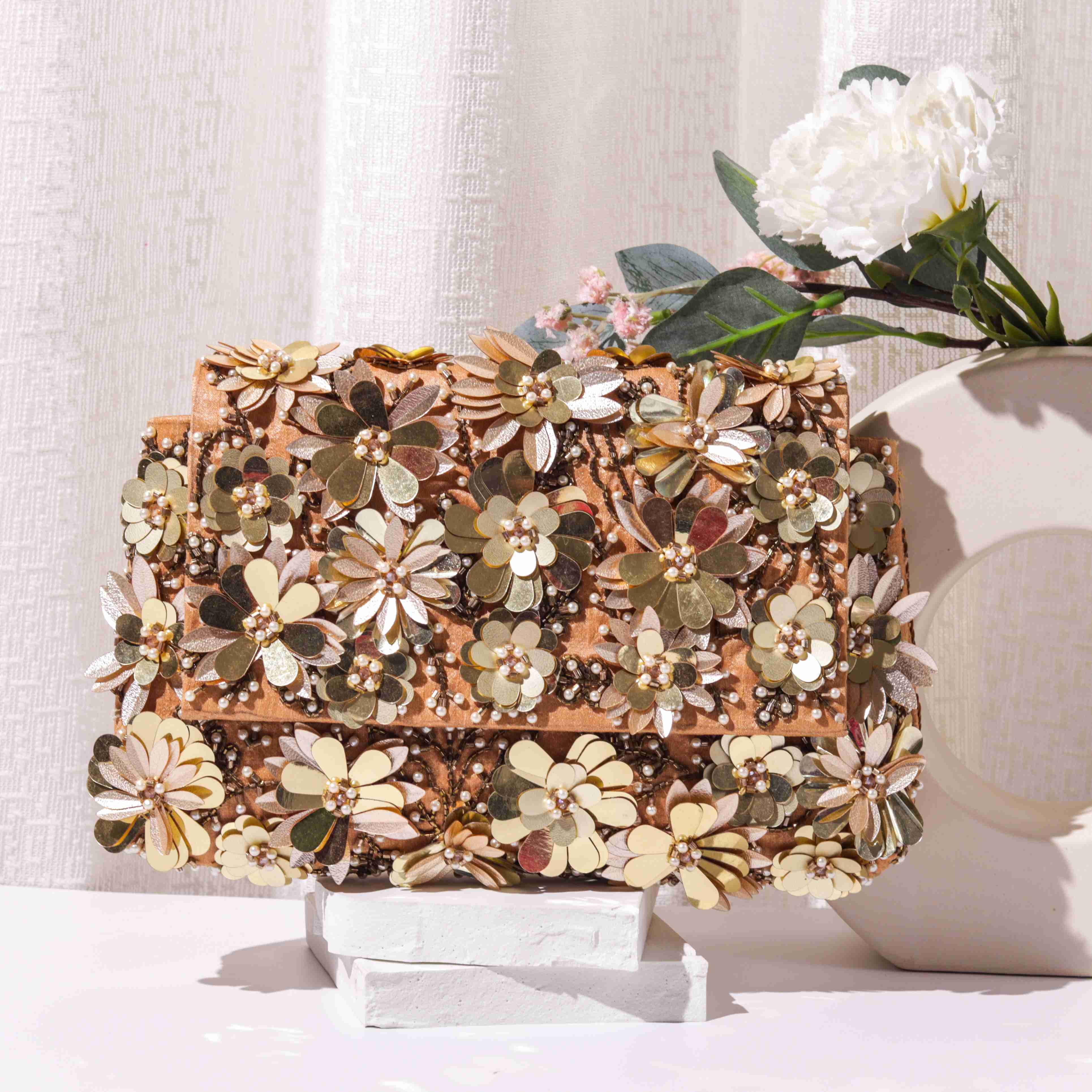 A model showcasing Flower Striker Clutch by The Purple Sack from The Purple Sack's collection