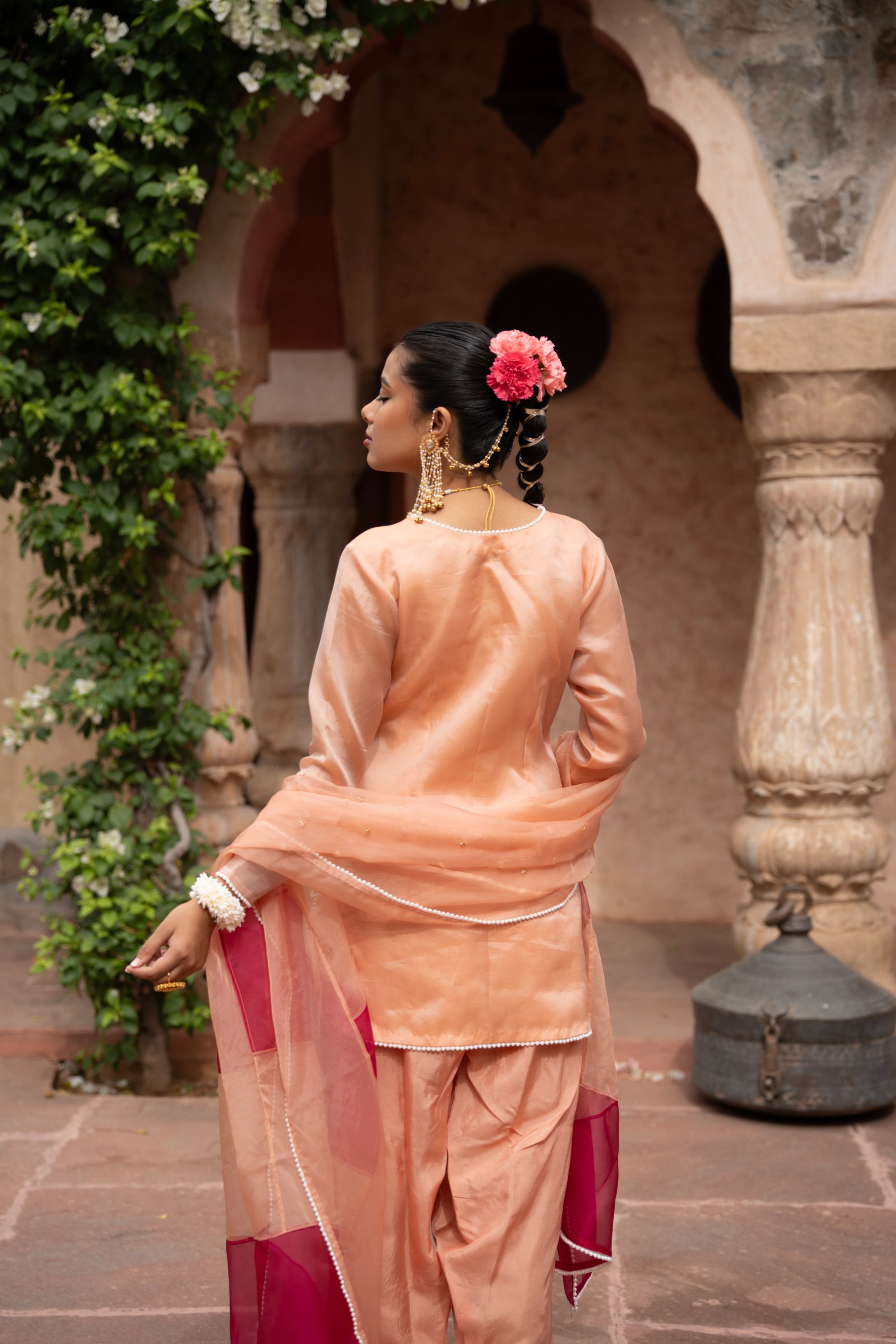 A model showcasing Peach Pink Handembroidered Farshi Set by Nikunj from Nikunj's collection