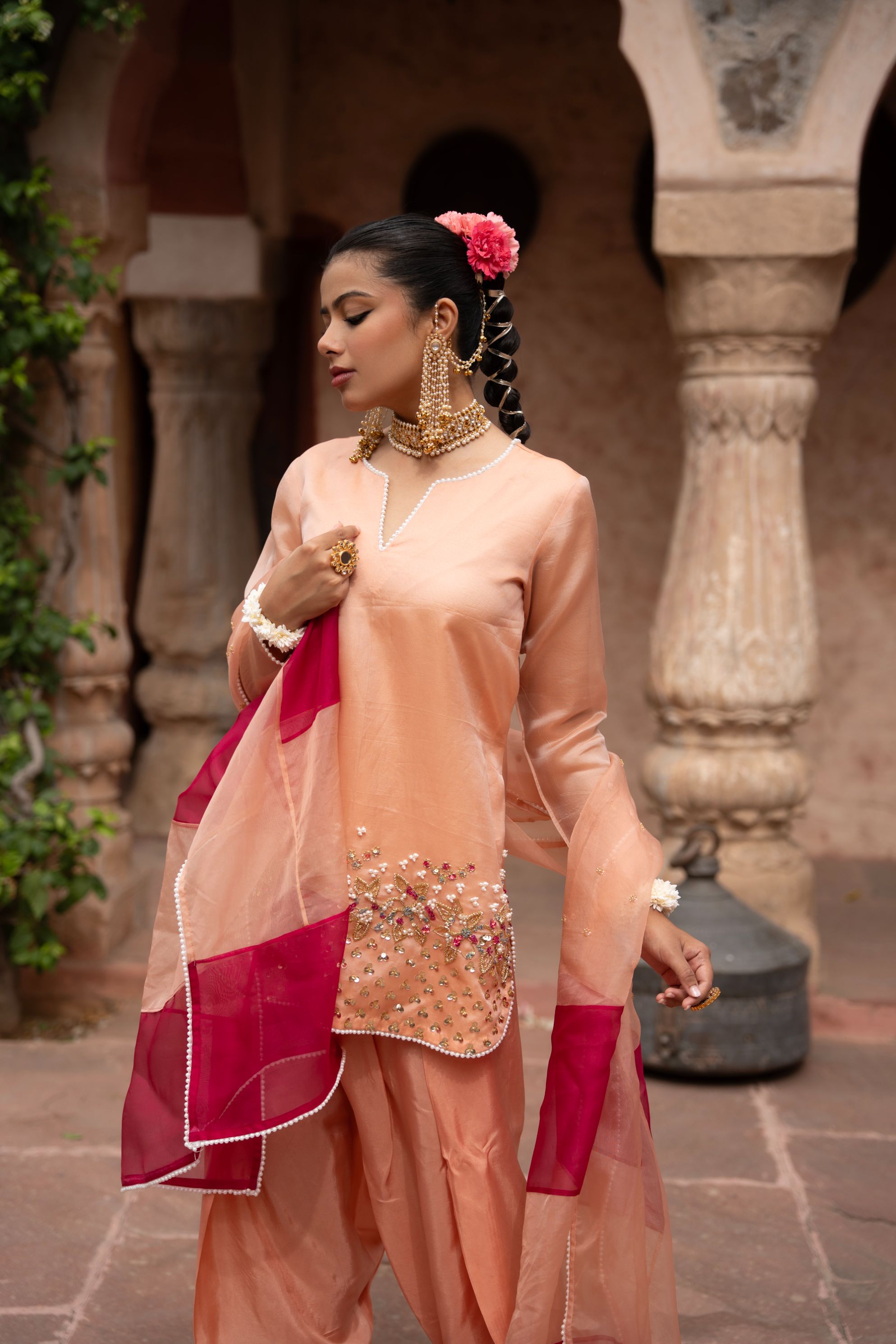 A model showcasing Peach Pink Handembroidered Farshi Set by Nikunj from Nikunj's collection