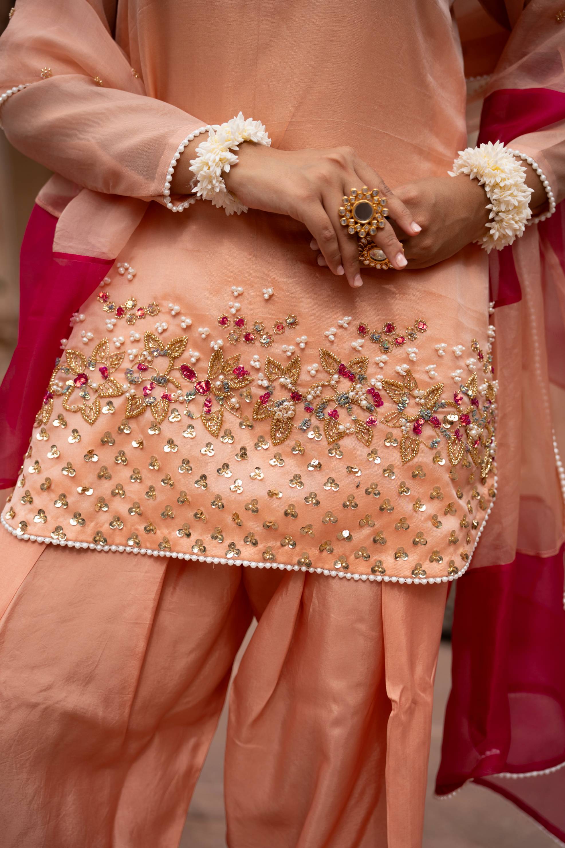 A model showcasing Peach Pink Handembroidered Farshi Set by Nikunj from Nikunj's collection