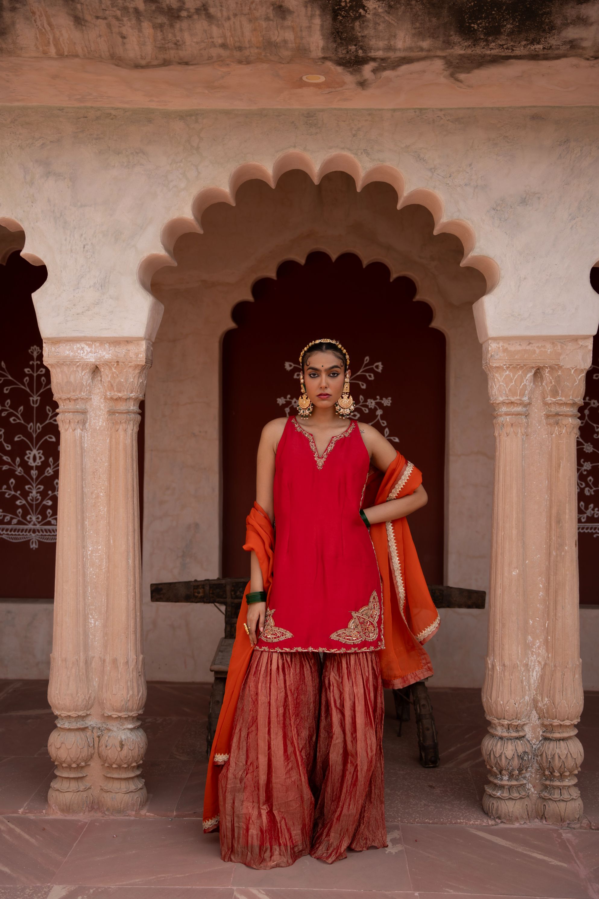 A model showcasing Laal Rang Handembroidered Gharara Set by Nikunj from Nikunj's collection
