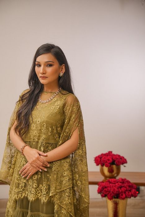 A model showcasing Khaki Tier Skirt With Cape by Myra By Anju Narian from Myra By Anju Narian's collection A model showcasing Khaki Tier Skirt With Cape by Myra By Anju Narian from Myra By Anju Narian's collection