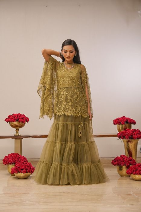 A model showcasing Khaki Tier Skirt With Cape by Myra By Anju Narian from Myra By Anju Narian's collection