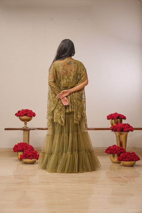 A model showcasing Khaki Tier Skirt With Cape by Myra By Anju Narian from Myra By Anju Narian's collection A model showcasing Khaki Tier Skirt With Cape by Myra By Anju Narian from Myra By Anju Narian's collection