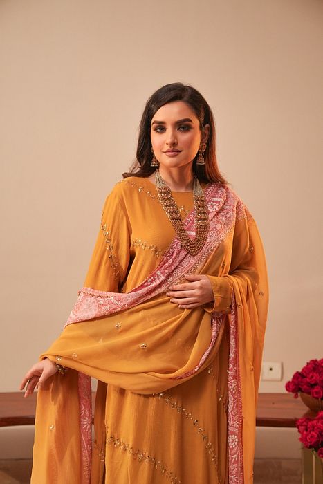 A model showcasing Mustard Mukaish Kurta With Shaded Dupatta by Myra By Anju Narian from Myra By Anju Narian's collection A model showcasing Mustard Mukaish Kurta With Shaded Dupatta by Myra By Anju Narian from Myra By Anju Narian's collection