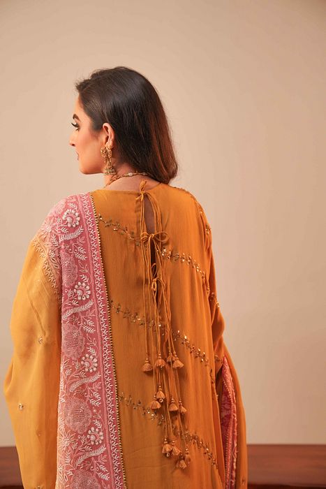 A model showcasing Mustard Mukaish Kurta With Shaded Dupatta by Myra By Anju Narian from Myra By Anju Narian's collection A model showcasing Mustard Mukaish Kurta With Shaded Dupatta by Myra By Anju Narian from Myra By Anju Narian's collection