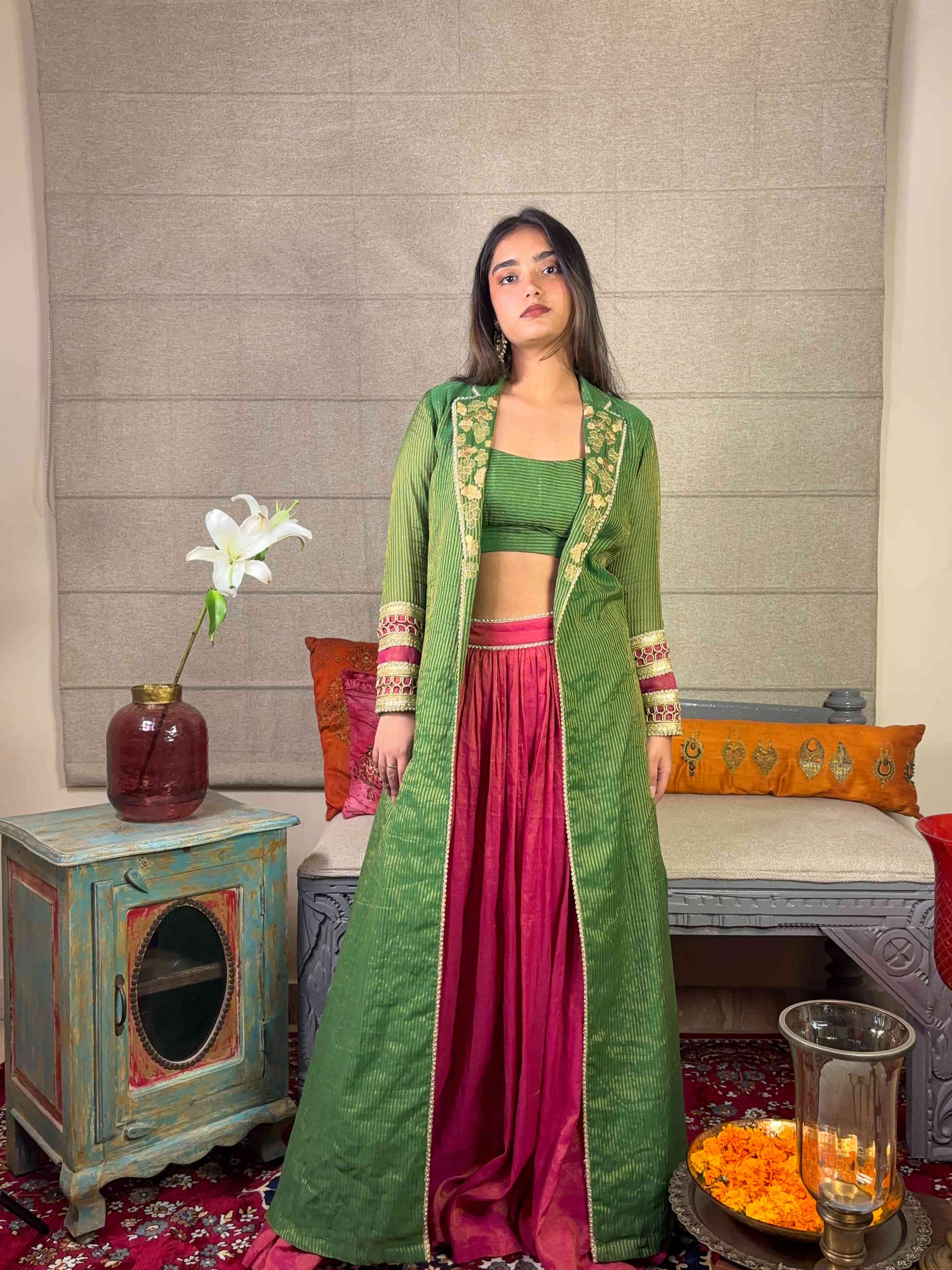 A model showcasing Banarsi Long Green Cape With Skirt Set by Miithhii Elaychii from Miithhii Elaychii's collection
