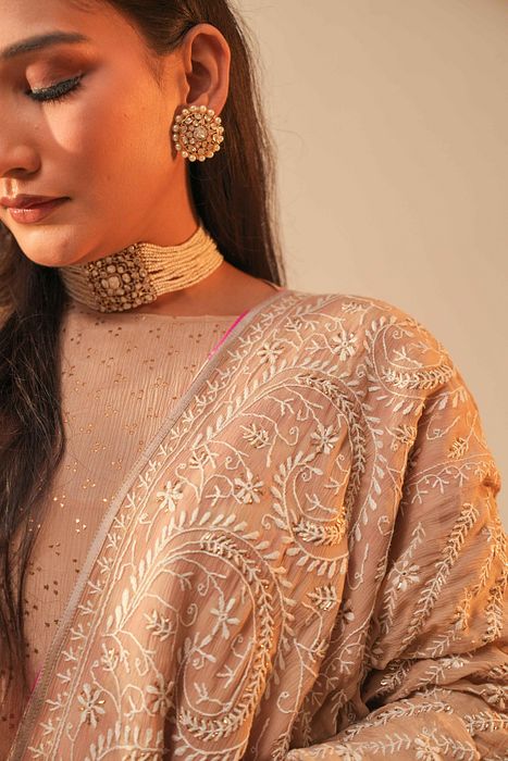 A model showcasing Beige Mukaish Kurta With Heavy Chikan Dupatta by Myra By Anju Narian from Myra By Anju Narian's collection A model showcasing Beige Mukaish Kurta With Heavy Chikan Dupatta by Myra By Anju Narian from Myra By Anju Narian's collection