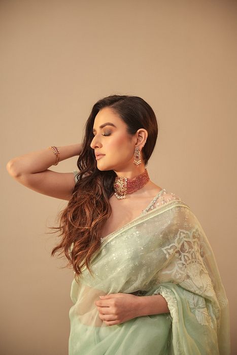 A model showcasing Ice Blue Chikankari Saree With Net Blouse by Myra By Anju Narian from Myra By Anju Narian's collection A model showcasing Ice Blue Chikankari Saree With Net Blouse by Myra By Anju Narian from Myra By Anju Narian's collection