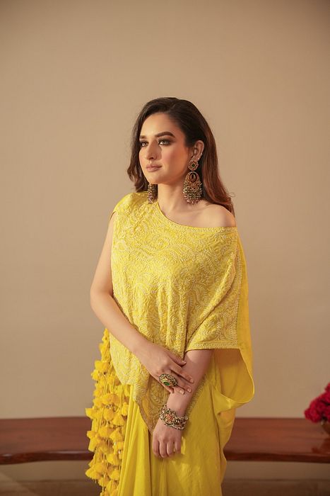 A model showcasing Chikankari Asymmetrical Tunic With Tassels And Dhoti by Myra By Anju Narian from Myra By Anju Narian's collection A model showcasing Chikankari Asymmetrical Tunic With Tassels And Dhoti by Myra By Anju Narian from Myra By Anju Narian's collection