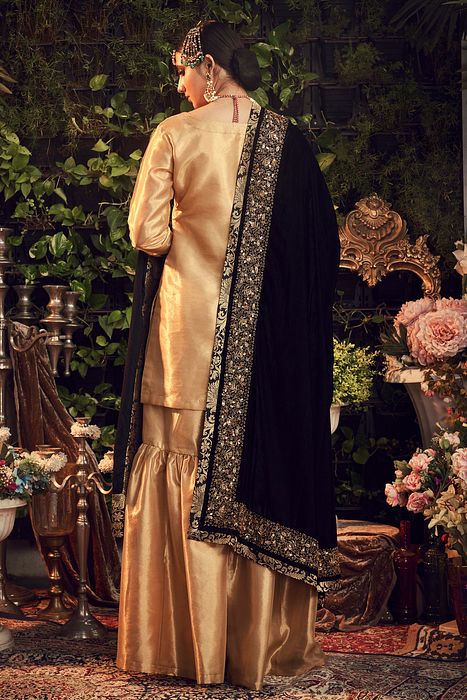 A model showcasing Oxidised Gold Sharara Set by Ranian from Ranian's collection A model showcasing Oxidised Gold Sharara Set by Ranian from Ranian's collection