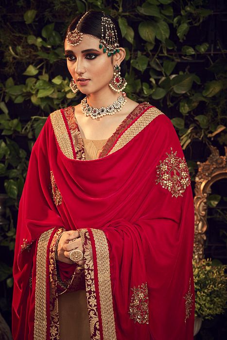A model showcasing Oxidised Gold Garara Set With Red Velvet Dupatta by Ranian from Ranian's collection A model showcasing Oxidised Gold Garara Set With Red Velvet Dupatta by Ranian from Ranian's collection