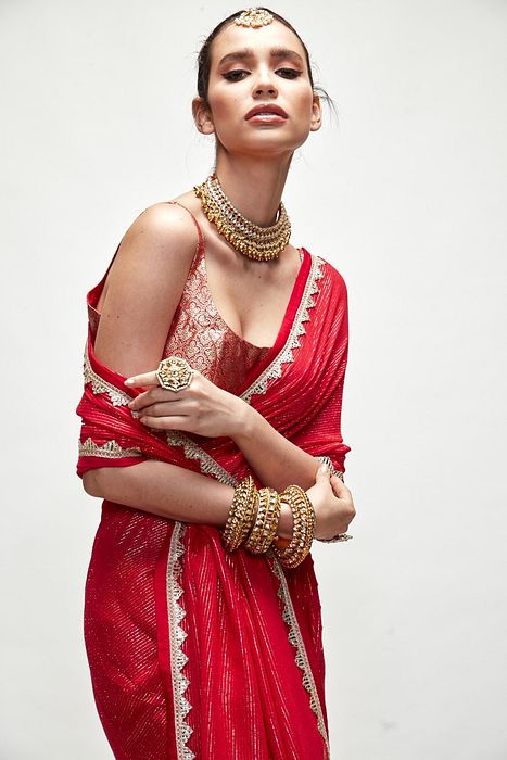 A model showcasing Carmine Red Mettalic Saree Set by Ranian from Ranian's collection A model showcasing Carmine Red Mettalic Saree Set by Ranian from Ranian's collection