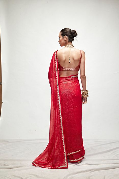 A model showcasing Carmine Red Mettalic Saree Set by Ranian from Ranian's collection A model showcasing Carmine Red Mettalic Saree Set by Ranian from Ranian's collection