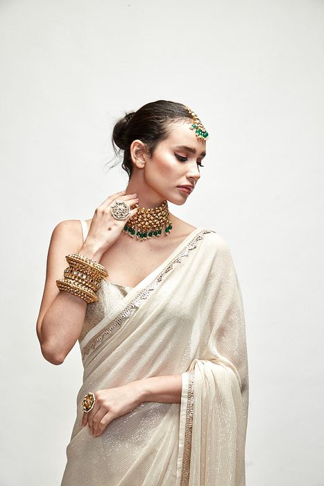 A model showcasing Porcelain Cream Mettalic Saree Set by Ranian from Ranian's collection A model showcasing Porcelain Cream Mettalic Saree Set by Ranian from Ranian's collection