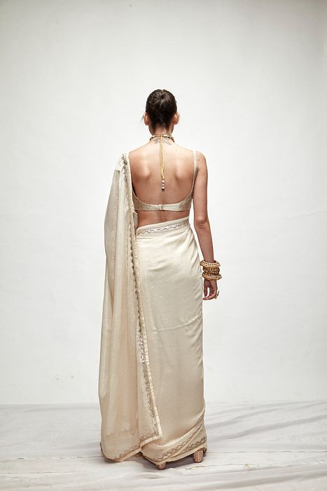 A model showcasing Porcelain Cream Mettalic Saree Set by Ranian from Ranian's collection A model showcasing Porcelain Cream Mettalic Saree Set by Ranian from Ranian's collection