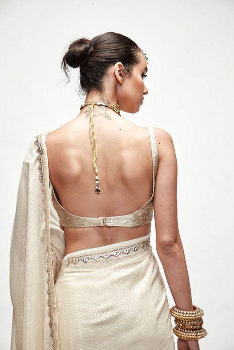 A model showcasing Porcelain Cream Mettalic Saree Set by Ranian from Ranian's collection A model showcasing Porcelain Cream Mettalic Saree Set by Ranian from Ranian's collection