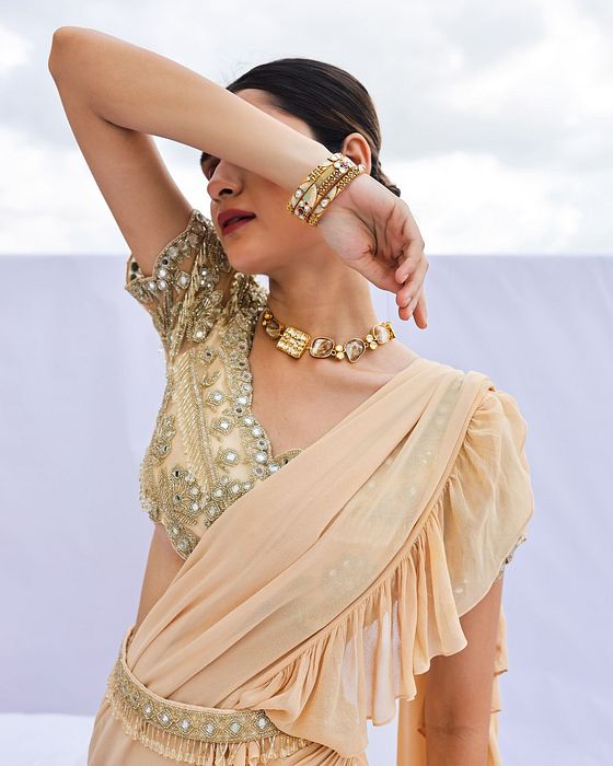 A model showcasing Gold Embroidered Predraped Ruffle Saree Set by Foram Patel from Foram Patel's collection
