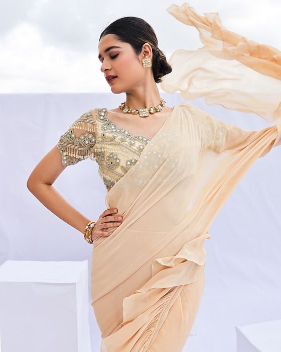 A model showcasing Gold Embroidered Predraped Ruffle Saree Set by Foram Patel from Foram Patel's collection