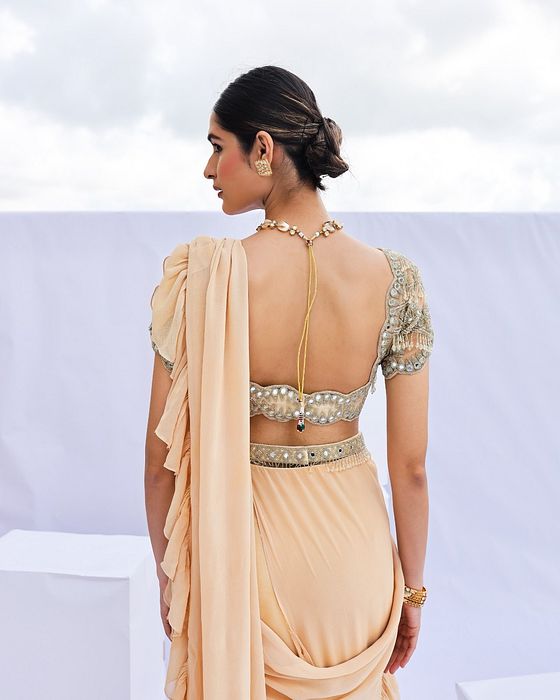 A model showcasing Gold Embroidered Predraped Ruffle Saree Set by Foram Patel from Foram Patel's collection