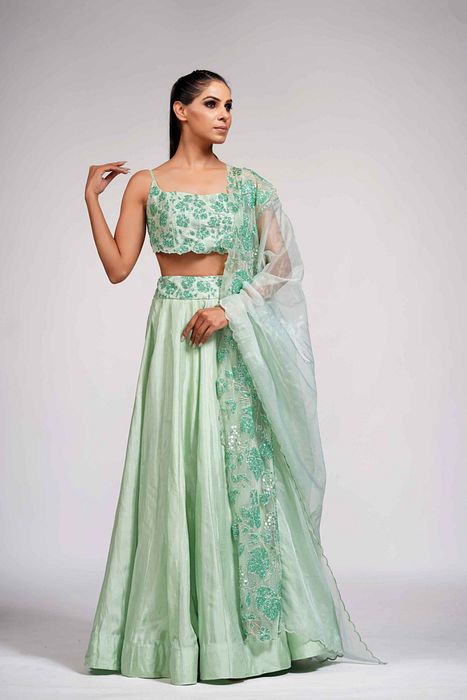 A model showcasing Green Grapewine Cutwork Blouse N Dupatta With Silk Lehenga by Shruti S Label from Shruti S Label's collection