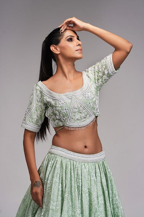 A model showcasing Sage Green Lehenga With Offwhite Hand Paint And Pearl Embroidery by Shruti S Label from Shruti S Label's collection