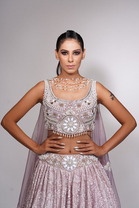 A model showcasing Lilac Lehenga With Offwhite Hand Paint Pearl Embroidery by Shruti S Label from Shruti S Label's collection