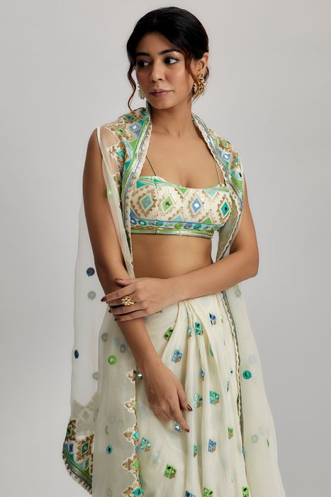 A model showcasing The Imrat Cape Set With Skirt In Ivory by Gopi Vaid from Gopi Vaid's collection
