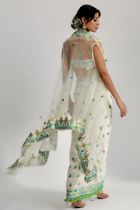 A model showcasing The Imrat Cape Set With Skirt In Ivory by Gopi Vaid from Gopi Vaid's collection