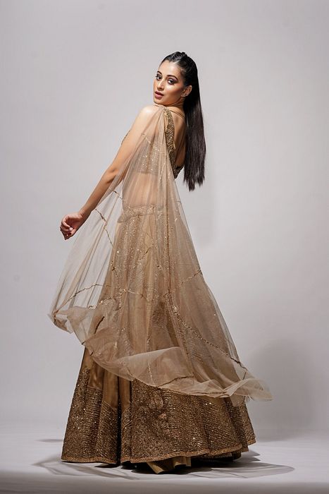 A model showcasing Gold Constructed Bustier Lehenga by Shruti S Label from Shruti S Label's collection