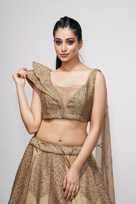 A model showcasing Gold Constructed Bustier Lehenga by Shruti S Label from Shruti S Label's collection