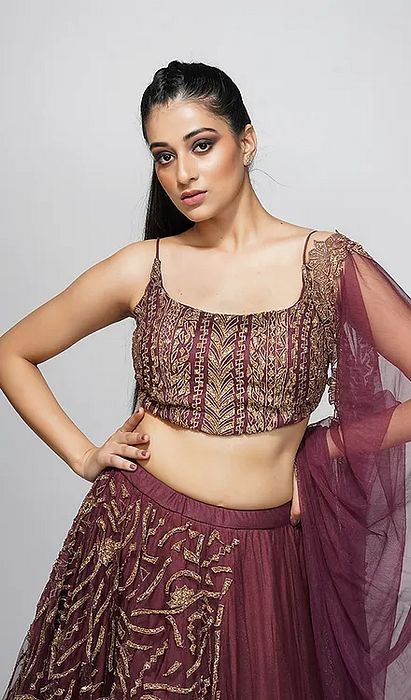 A model showcasing Tavus Wine Gold Half Half Lehenga by Shruti S Label from Shruti S Label's collection