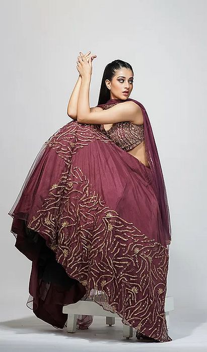 A model showcasing Tavus Wine Gold Half Half Lehenga by Shruti S Label from Shruti S Label's collection