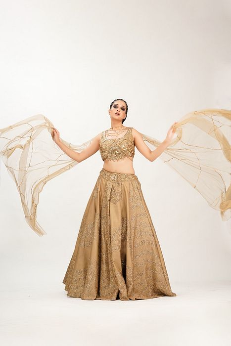 A model showcasing Gold Midal Touch Lehenga by Shruti S Label from Shruti S Label's collection