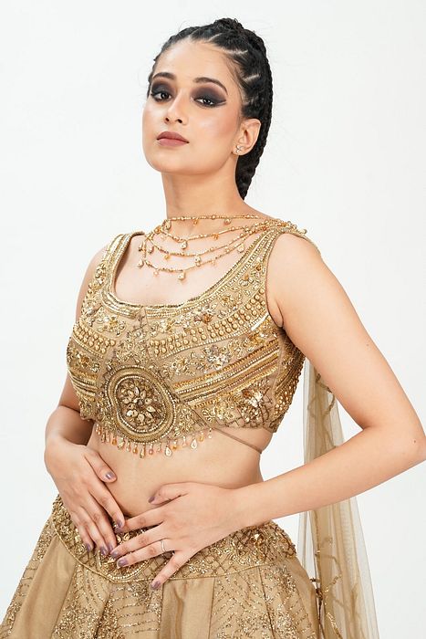 A model showcasing Gold Midal Touch Lehenga by Shruti S Label from Shruti S Label's collection