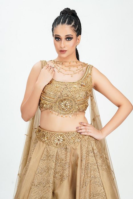 A model showcasing Gold Midal Touch Lehenga by Shruti S Label from Shruti S Label's collection