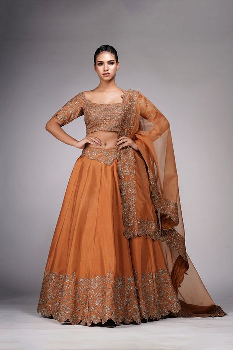 A model showcasing Cinnamon Classic Heavy Bordered Lehenga by Shruti S Label from Shruti S Label's collection