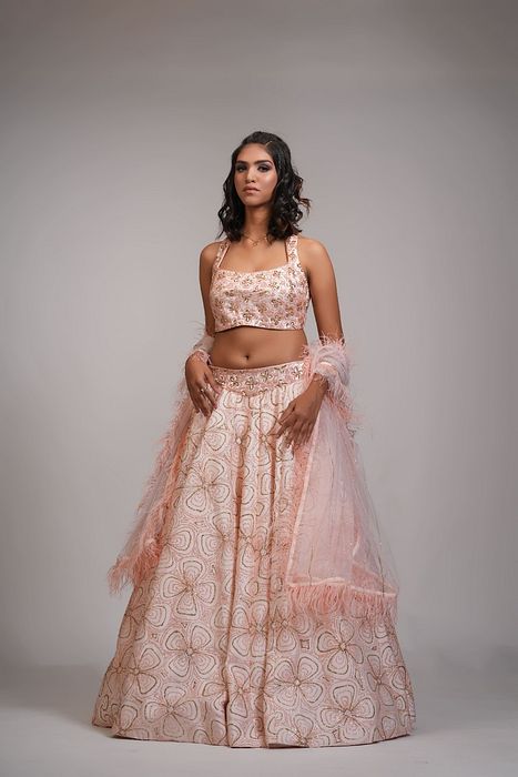 A model showcasing Peach Heavy Embroidered Lehenga With Feathers On Dupatta by Shruti S Label from Shruti S Label's collection
