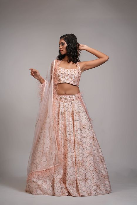 A model showcasing Peach Heavy Embroidered Lehenga With Feathers On Dupatta by Shruti S Label from Shruti S Label's collection