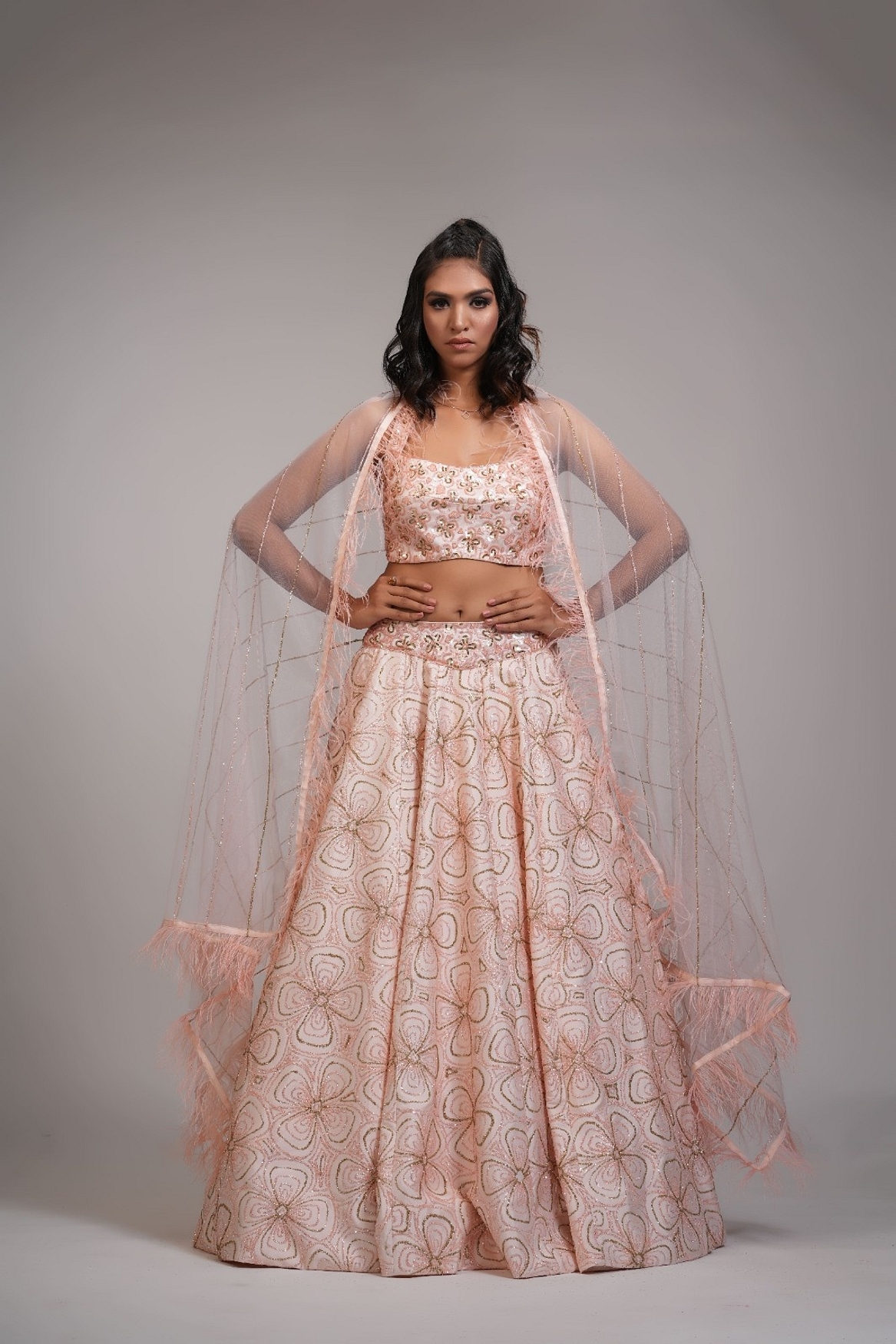 A model showcasing Peach Heavy Embroidered Lehenga With Feathers On Dupatta Feature image by Shruti S Label from Shruti S Label's collection