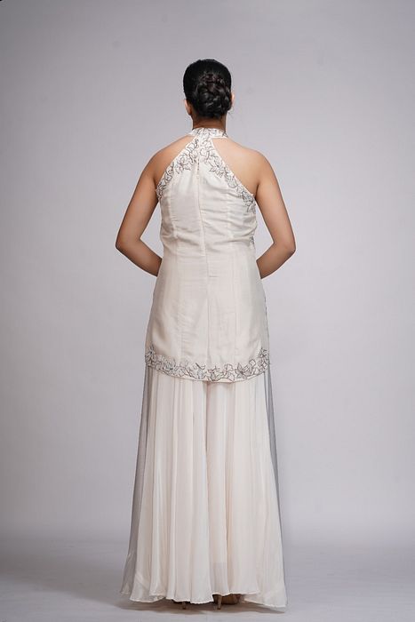 A model showcasing White Embroidery Halter Neck Sharara by Shruti S Label from Shruti S Label's collection