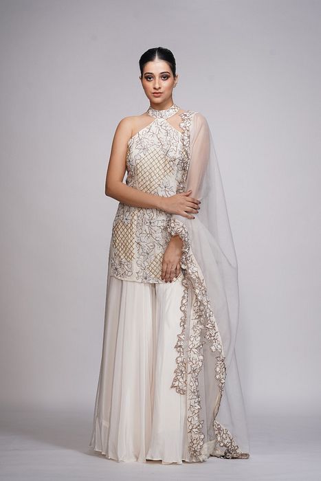 A model showcasing White Embroidery Halter Neck Sharara by Shruti S Label from Shruti S Label's collection