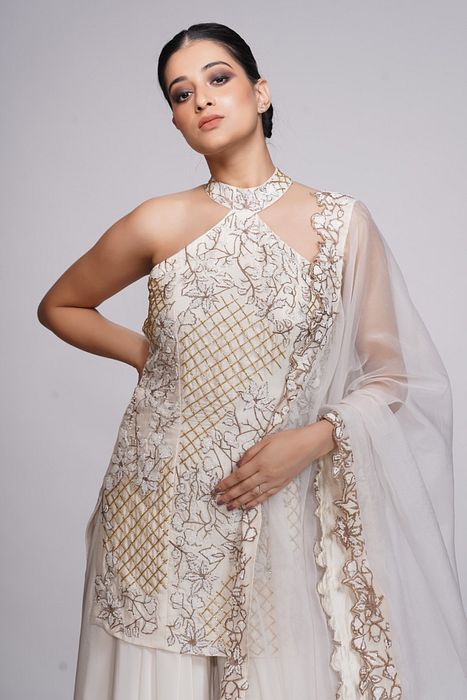 A model showcasing White Embroidery Halter Neck Sharara by Shruti S Label from Shruti S Label's collection