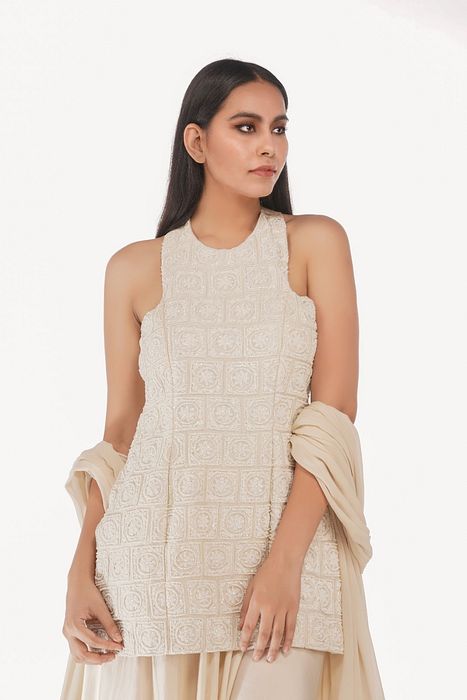 A model showcasing Off White Racer Cut Sharara Suit by Shruti S Label from Shruti S Label's collection A model showcasing Off White Racer Cut Sharara Suit by Shruti S Label from Shruti S Label's collection