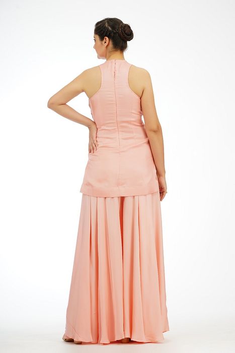 A model showcasing Peach Racer Cut Sharara Suit by Shruti S Label from Shruti S Label's collection