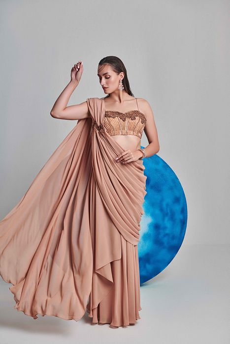 A model showcasing Beige Flared Pre Stitched Drape Saree by One Knot One from One Knot One's collection