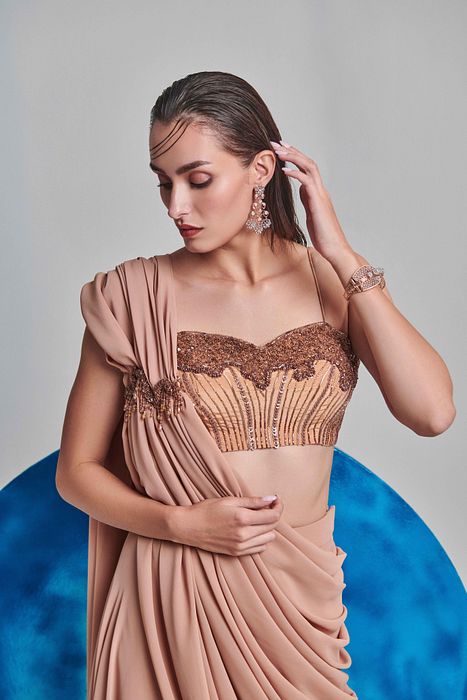 A model showcasing Beige Flared Pre Stitched Drape Saree by One Knot One from One Knot One's collection