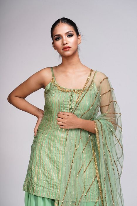 A model showcasing Silk Sharara Suit In Sage Green by Shruti S Label from Shruti S Label's collection