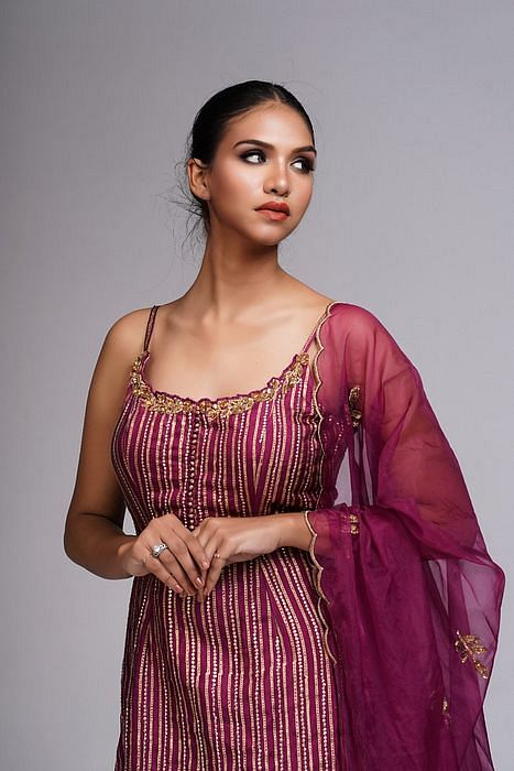 A model showcasing Hand Work Block Print Wine Sharara Suit by Shruti S Label from Shruti S Label's collection